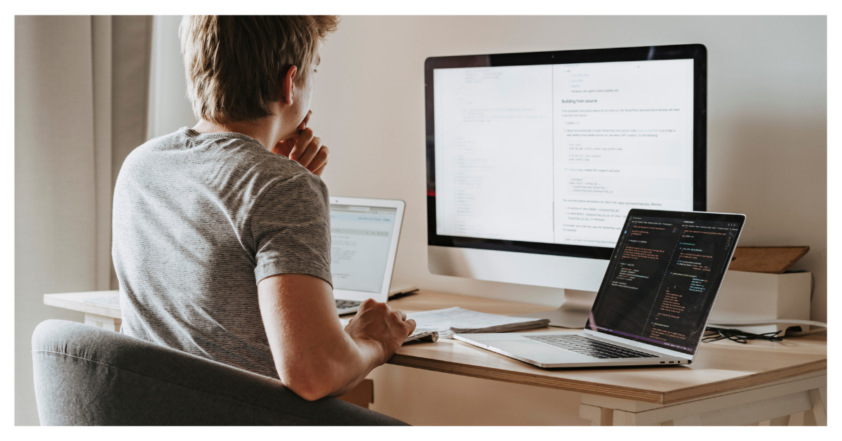 Person working at a desk with multiple screens, reading technical content—symbolizing focused cybersecurity awareness and digital risk analysis.